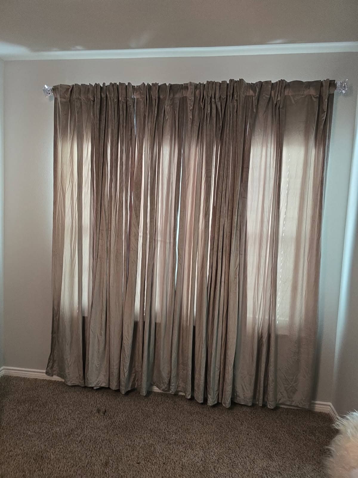 Floor-length curtains hanging from a new rod over a bedroom window