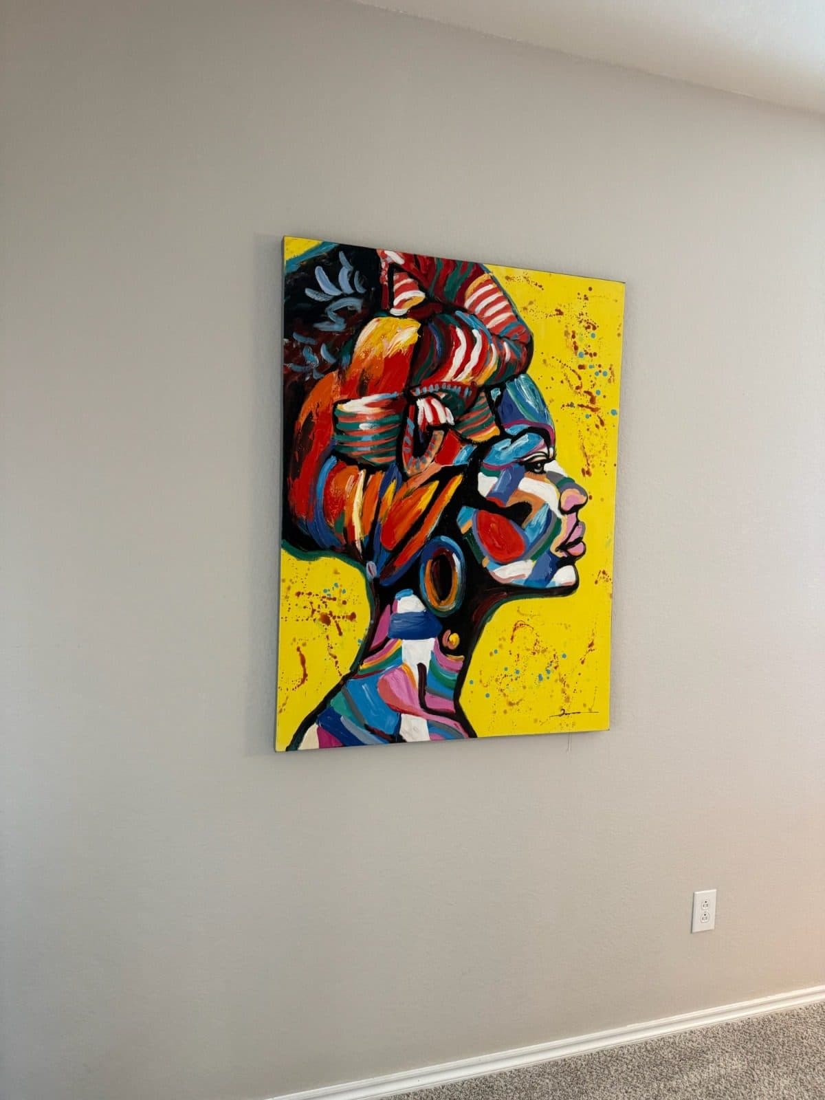 Large colorful canvas portrait hung level on a pale gray bedroom wall