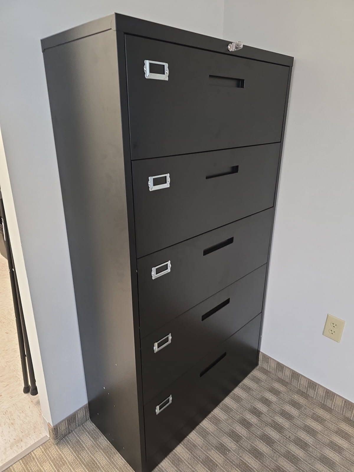 Black five-drawer lateral file cabinet assembled in a home office corner