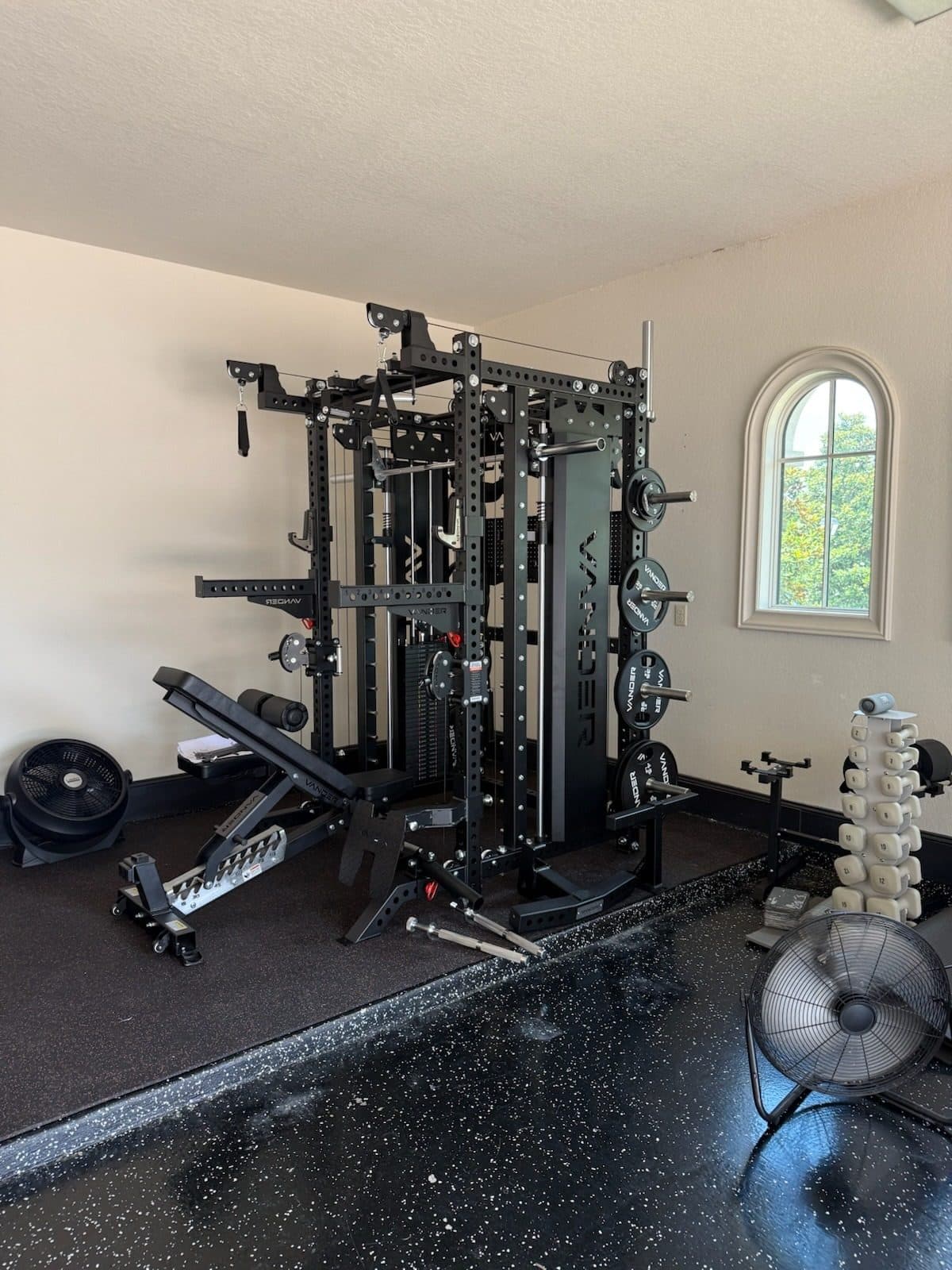 Black power rack with a cable system and an adjustable bench assembled on rubber gym flooring